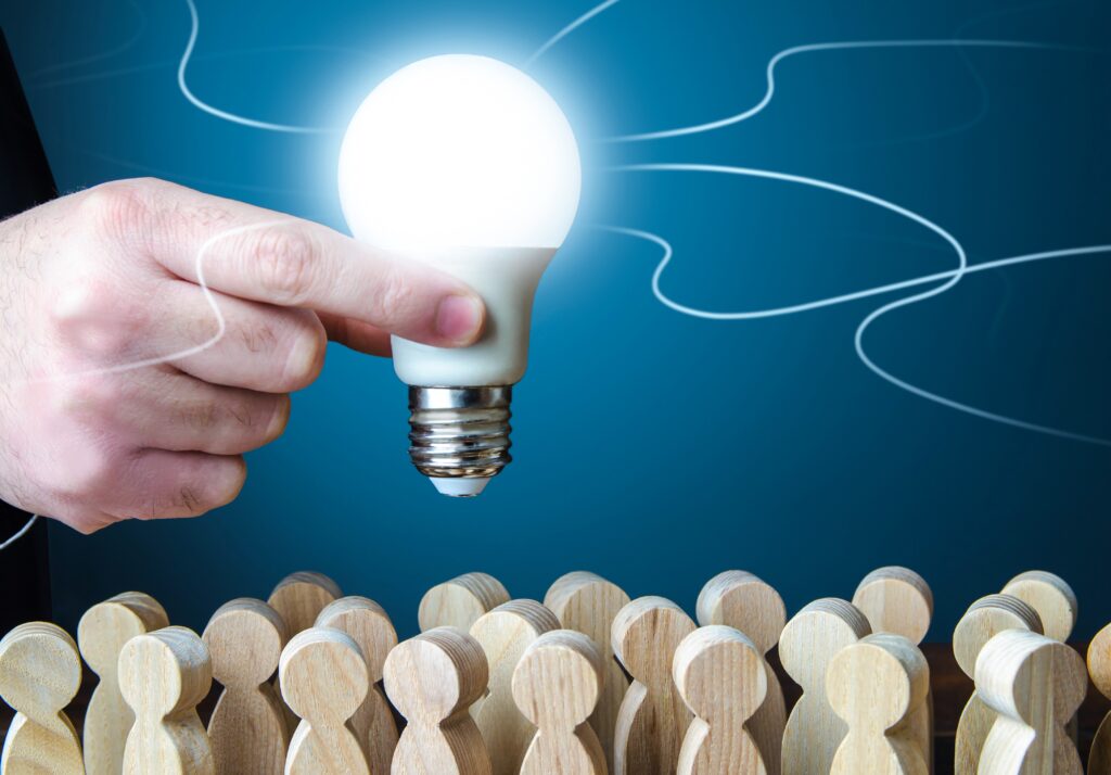 A man holds an idea light bulb above the crowd, intellectual property