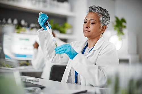 Woman working in a lab, biotech trade secrets.